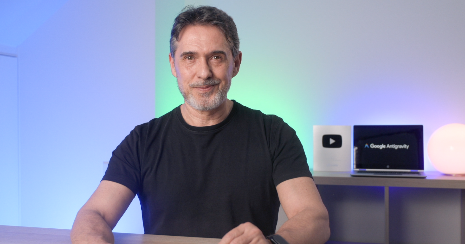 Luis Alfonso Ruiz, creador de EdTrainer TV, con el botón de plata de YouTube y Google Antigravity al fondo